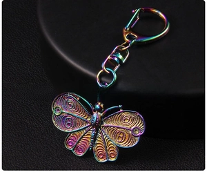 Macro detail of Y2K butterfly keychain featuring iridescent plating and hollow patterns