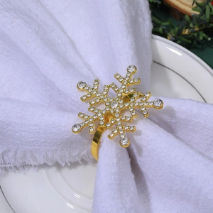 Close-up of gold snowflake napkin ring with rhinestones on a white linen napkin
