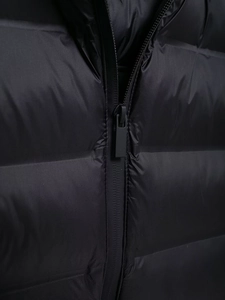 Detailed close-up of zipper closure and black quilted fabric on women hooded jacket