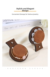 Detail of walnut wood jewelry display stands with brown velvet cushions for luxury storage