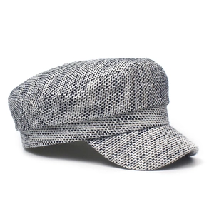 Detail of grey tweed newsboy cap showing textured weave and stiff brim on white background
