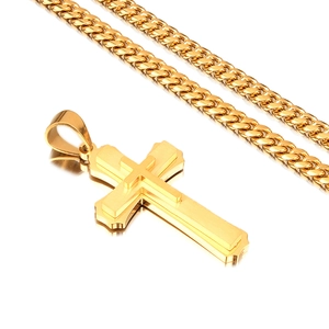 Detailed close-up of golden dual-layer cross pendant on a classic Cuban link chain necklace