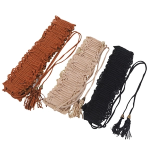 Detailed view of elastic waist belts in brown, beige, and black with fringe tassels