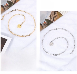 Close-up of gold and silver heart pendants with Love engraving on link chains