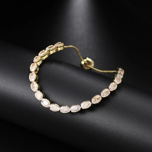 Detail of adjustable gold tennis bracelet with oval-cut crystals on a display