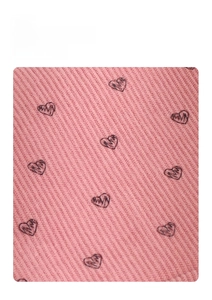 Detail of pink corduroy fabric featuring heart pattern print and soft texture