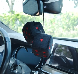 Close-up of black plush dice car mirror hanging accessories with red heart patterns