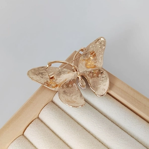 Back view of elegant butterfly brooch with gold metal pin closure on jewelry box