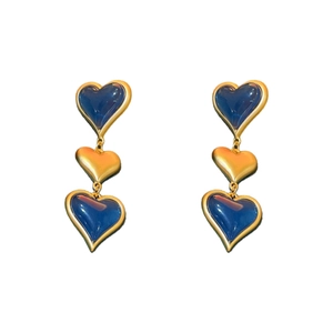 Vintage long gold earrings featuring three layered blue heart pendants on a white background