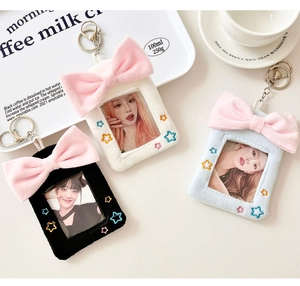 Dettaglio di porta fotocard in peluche con fiocchi rosa e ricami a stella