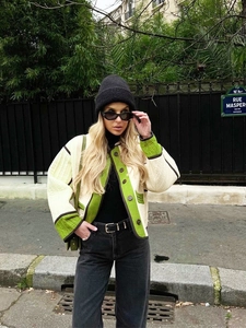 Detail of off-white quilted jacket with green piping and brown buttons for autumn style
