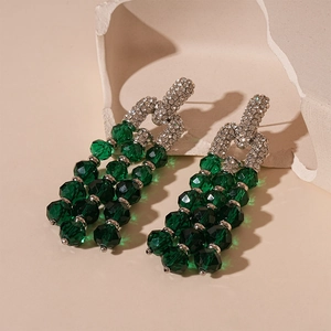 Detail of luxury green crystal tassel earrings with sparkling rhinestones in silver finish