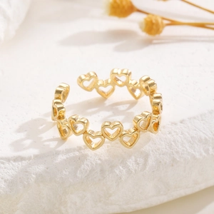 Detail eines verstellbaren goldenen Rings mit durchgehendem hohlem herzförmigem Muster