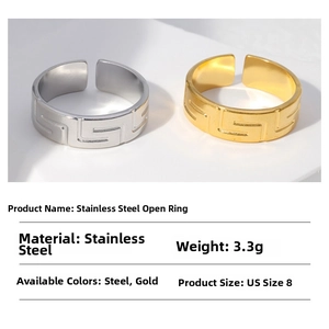 Macro detail of minimalist stainless steel open rings with Greek key pattern in gold and silver