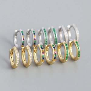 Macro detail of six pairs of s925 silver hoop earrings with colorful gemstones