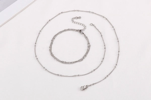 Detail of silver stainless steel curb and bead chain set featuring secure lobster clasps