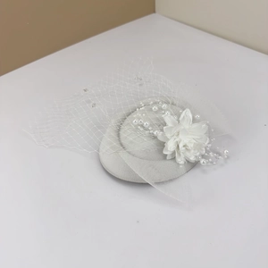 Elegant white bridal fascinator hat with handmade flower and mesh veil for weddings