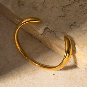 Dettaglio del bracciale rigido irregolare in acciaio inox placcato oro 18k su pietra