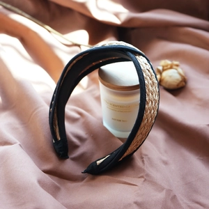 Detail of French vintage raffia straw headband with black fabric edges on brown cloth