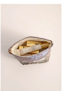 Detailed interior of jacquard makeup bag with gold thread patterns and zipper pocket