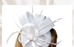 Detail of white fascinator hair clip with mesh fabric and soft feather accents