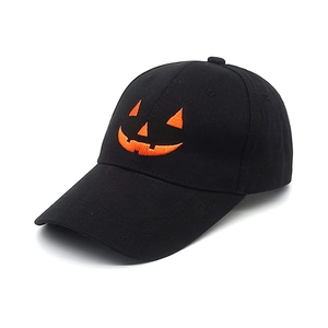 Detail showing high-quality orange pumpkin face embroidery on black baseball cap crown