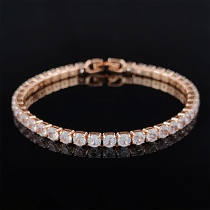 Detail of rose gold tennis bracelet with cubic zirconia on black reflective surface