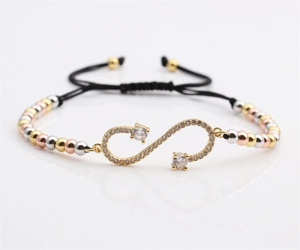 Detail of adjustable black woven bracelet featuring cubic zirconia infinity charm and metal beads