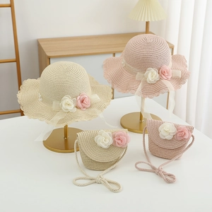 Detail of straw hat with lace ties and matching floral bag on a cozy wooden table
