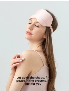 Close-up of a pink silk sleep mask with an elastic strap on a model for light blocking