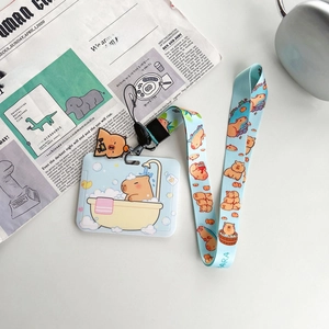 Detail of Capybara card holder set with blue lanyard and cute charm on newspaper background