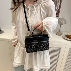 Vintage crossbody box bag with black leather and gold tweed pattern displayed on a model