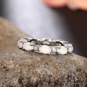 Détail macro d'une bague empilable avec opales de feu ovales et accents de zircon