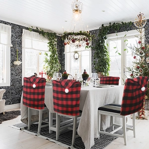 Festive red and black buffalo plaid Christmas chair covers with white decorative pompoms