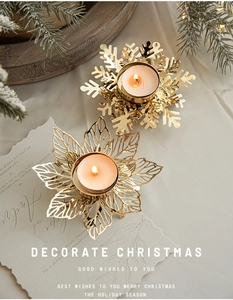 Detail of golden metal snowflake and leaf candle holders with glowing tea lights