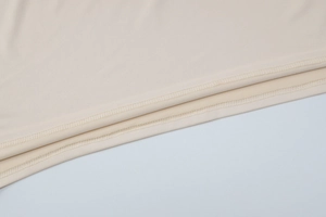 Gros plan détaillé des coutures à double aiguille sur l'ourlet d'une robe longue beige