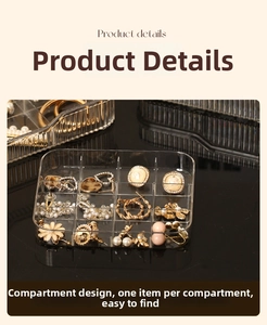 Close-up of 12-grid clear acrylic jewelry box storing earrings and rings on black background