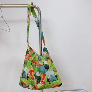Detailed view of large capacity cotton crossbody bag with vibrant green nature illustration