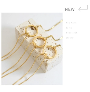 Detailed macro of gold ring necklace with multi-strand bead chains on stone