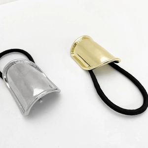 Close-up of gold and silver minimalist metal ponytail cuffs with black elastic hair ties