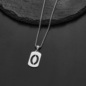 Detail of silver stainless steel necklace with rectangular hollow pendant on stone