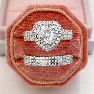 Macro shot of a two-piece heart-shaped zircon wedding set in a pink hexagonal box