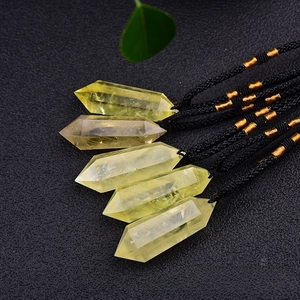 Close-up of five natural yellow citrine double point pendants with black woven cords