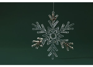 Macro shot of transparent acrylic snowflake ornament with sparkling gold sequins