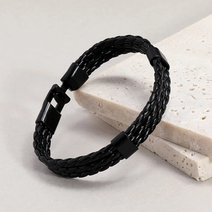 Close-up of black braided leather bracelet with matte metal buckle on stone plate