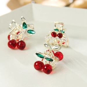 Detailed view of alloy cherry hair clips with red crystals and green rhinestone leaves