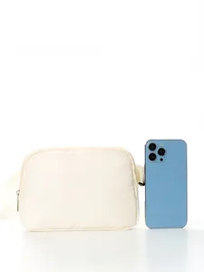 Size comparison of ivory nylon waist bag with a smartphone on a clean white background