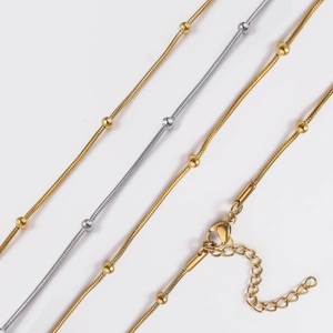 Detail of 18K gold and silver plated snake bone chains with beads and lobster clasps