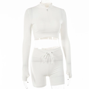 Detail of white ribbed long sleeve crop top with half-zip collar and thumb holes