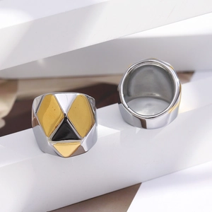 Détail d'une bague large en acier inoxydable avec motif géométrique or 18K et noir